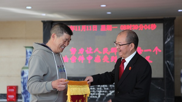 当事人将锦旗送到法官手中.jpg
